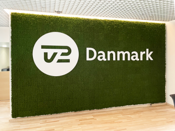 Grøn mosvæg med hvidt logo